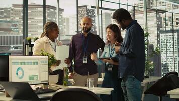 Motivated coworkers in diverse office starting project, showing enthusiasm. Joyous multiracial colleagues gathered together to solve company tasks, showing strong bond and camaraderie, camera B video