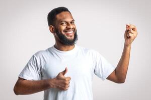 Great Taste. Cheerful Black Man Gesturing Thumbs Up Approving Taste Standing Posing Over White Studio Background, Smiling To Camera. Yummy, I Like This Meal Concept. photo