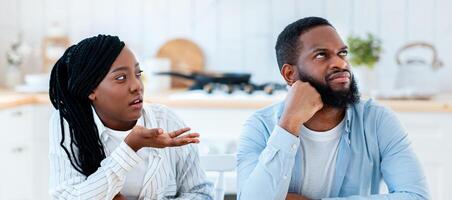Annoyed Black Man Listening Complaints From Wife In Kitchen At Home, Millennial African American Woman Blaming Husbang For Problems In Marriage, Suffering Relationship Crisis, Copy Space photo