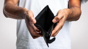 No Money. Unrecognizable Unemployed Black Man Showing Empty Wallet Standing Over White Studio Background. Bankruptcy, Unemployment And Poverty, Financial Crisis Concept. Cropped, Closeup photo