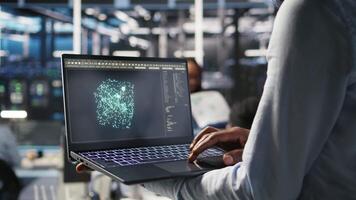 cerca arriba de datos centrar trabajador utilizando ordenador portátil a interpretar datos analítica gráficos servidor habitación técnico utilizando artificial inteligencia en cuaderno mostrando sistema métrica, cámara un video