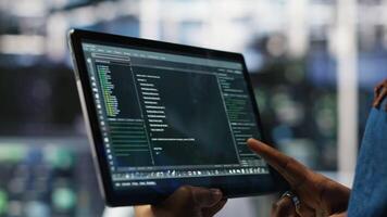 Vertical Close up of data center software developer checking code on tablet used to update equipment. Server hub expert using programming language script on device to do maintenance, camera B video
