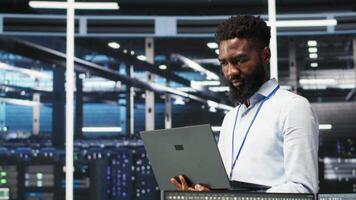 Portrait of cheerful data center engineer analyzing gear issues using node tree tools. Upbeat African american server hub specialist using AI visualization insights to optimize system health, camera B video