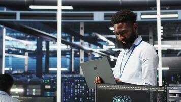 Data center engineer doing node tree programming to optimize resource allocation. Server farm specialist using predictive AI visualization systems for maintenance planning, camera B video