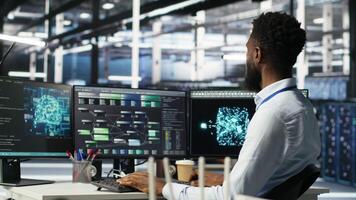 Vertical Data center programmer uses machine learning node tree program to identify equipment issues. Server hub worker reviewing artificial intelligence data analysis graph to minimize failures, camera B video