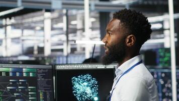 Vertical Server hub admin using AI neural network node tree program to optimize system health. Data center IT professional analyzing equipment issues using deep learning AI visualization, camera B video