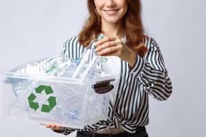 Waste For Recycling. Smiling Lady Putting Empty Plastic Bottle To Container Box In Her Hands, Cheerful Unrecognizable Woman Enjoying Garbage Sorting And Eco-Friendly Living, Cropped Image, Closeup photo