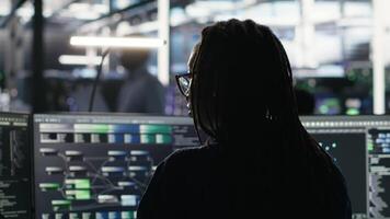 Les données centre ingénieur en utilisant algorithmes à analyser grand des ensembles de données, en mettant sur écouteurs. serveur ferme il professionnel en utilisant artificiel intelligence à reconnaître Les données motifs écoute musique, caméra b video