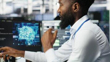Vertical Data center programmer uses neural networks node tree program to identify equipment issues. Server hub employee reviewing AI deep learning data analysis graph to minimize failures, camera B video
