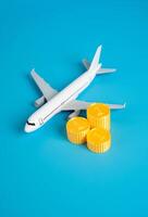 Airplane and a stack of coins. Flights and air traffic. Income and taxes. Saving on bonus programs. Ticket pricing, aviation taxation, airline profit. Travel budgeting, frequent flyer benefits photo