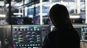 Vertical Server farm software developer interprets data analytics graphs. Data center specialist using artificial intelligence program showing predictive system metrics, camera B video