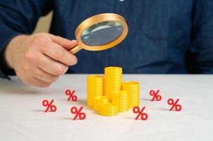 A man studies the financial market with all its costs, taxes and fees. Complexity of investment planning, budget awareness. Hidden pitfalls of financial systems, interest traps to service charges. photo
