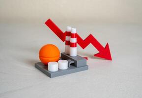 Industrial plant and red arrow down. Production decline, low revenue. Cost reduction. Credit rating decline. Crisis in industry. Economic downturn, job cuts, factory closures, declining orders. photo