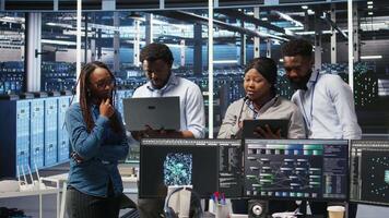 Portrait of smiling data center specialists collaborating in server facility, using node tree software to analyze datasets. Happy team using visual programming to improve gear performance, camera A video
