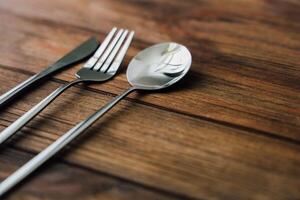 Elegant silverware arranged on wooden table for dining experience preparation photo