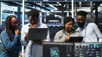 Vertical Portrait of smiling data center specialists collaborating in server facility, using node tree software to analyze datasets. Happy team using visual programming to improve gear performance, camera B video