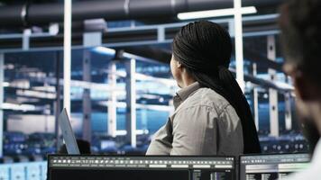 vertical dados Centro admin usando computador portátil para Faz nó árvore programação, otimizando recurso alocação. mulher dentro servidor quarto usa preditivo ai visualização sistemas em caderno para manutenção planejamento, Câmera b video