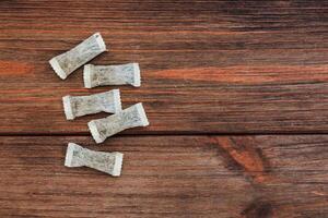 Nicotine snus pads, a smokeless alternative to cigarettes arranged on a wooden table showcasing a cozy tea moment at home in the afternoon photo
