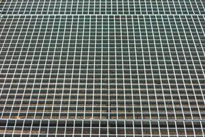 Metal grating surface with squares arranged in a pattern and detail of metallic texture photo