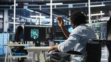 Man in wheelchair dissatisfied with server farm AI analytics metrics. Data center admin with paraplegia frustrated by glitches while automating tasks using node tree programming tool, camera A video