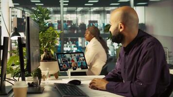 Worker in office talking with colleagues during internet videocall. Employee at work discussing with business partners during remote teleconference meeting, analyzing metrics, camera B video