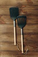 Cooking utensils including spatula and slotted turner on wooden table surface photo