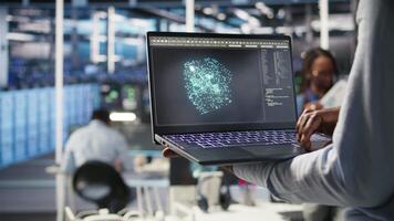 Close up of data center admin using machine learning algorithms on laptop to analyze large datasets. Server farm worker using artificial intelligence on notebook to recognize data patterns, camera A video