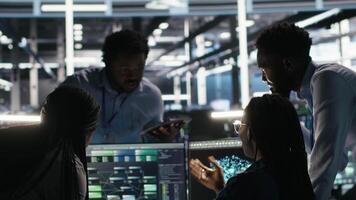 Vertical Data center coworkers doing brainstorming, using node tree software to analyze datasets. Server room teamworking colleagues using visual programming tools to improve gear performance, camera B video