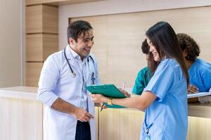 Team of doctor and nurse is discussing and brainstorming over patient medical record after diagnosis for precise care plan with experienced senior physician specialist photo