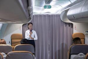 African flight attendant is greeting passenger to welcome on board to the flight and reporting the attitude, weather and route to the destination airport photo