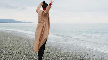 Dance For A Woman With Brown Coat To Get Rid Of Anxieties Near The Ocean video