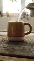 Vertical . Tea time. Pouring boiling water from kettle into mug. Morning breakfast with hot cup of tea. video