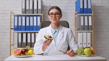 A healthcare professional evaluates fresh fruits at a desk in a clinic, emphasizing the importance of nutrition and healthy dietary choices. The atmosphere is professional and inviting. video