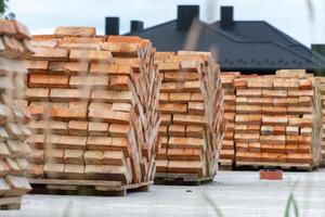 Numerous stacks of bricks are organized neatly at a construction site, indicating preparation for upcoming building projects in a suburban setting photo