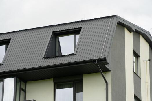 A contemporary building features a distinct angular roof design, complemented by large windows, capturing the essence of modern residential architecture photo