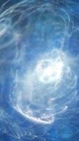 Abstract spiral burst of light and particles swirling in deep blue space, evoking a sense of cosmic energy and dynamic motion video