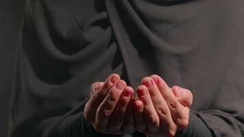 woman dressed in hijab gently cradles argan nuts in her hands. soft lighting creates warm and calming atmosphere emphasizing her focused expression video