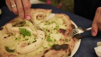 Hands Of A Man Cutting The Gourmet Fish Pizza With Fork And Knife video