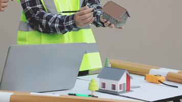 Two people working on a laptop and a model house video