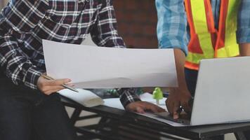 Two people working on a laptop in front of a table video