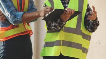 Two construction workers are talking on a clipboard video
