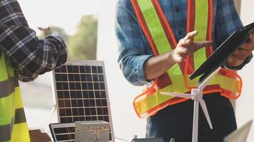Two men in safety vests and hard hats are working on a solar panel video
