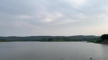 Beautiful natural view of the lake with a background of hills and rice fields video