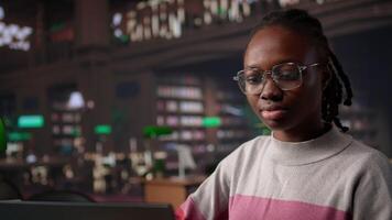 Preto menina estudando dentro universidade biblioteca para dela solteiro grau diploma, usando a educacional pesquisa coleção e geral base de dados para conhecimento. colecionar citações para papel. Câmera b. video