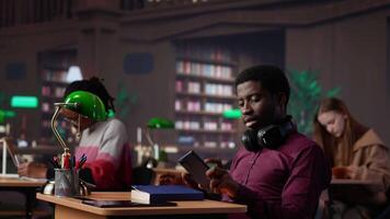 Rude man answering a phone call in the library and disturbing people, being very noisy. Students asking to keep quiet, losing focus and concentration while learning or reading. Camera A. video