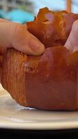 female hands break a puff pastry bun joining the edges together examining the structure of the puff pastry delicious pastries with chocolate round croissant video