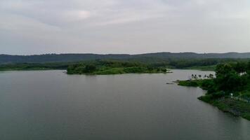 Beautiful view of artificial lake in the middle of green rice fields and hills video