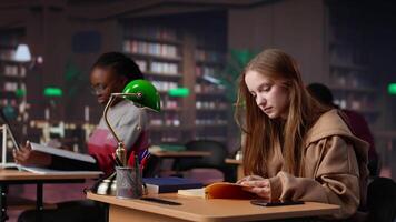 Noisy girl disturbing students at the library by speaking very loud on call, being rude and answering her phone in the study area. Disruptive annoying person asked to keep silence. Camera A. video