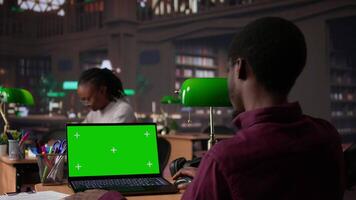 Faculdade aluna parece às uma cópia de espaço em computador portátil enquanto colecionar notas a partir de confiável acadêmico fontes, consultando a campus biblioteca livros coleção para a atribuição. aluna vida. Câmera b. video