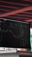 Vertical African american man using PC to purchase and sell stocks, monitoring forex graphs and diagrams. Male broker looking at stock exchange candle stick charts on computer. Camera A. video